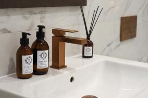 a bathroom sink with two bottles and a faucet at The Knaresborough Retreat in Knaresborough