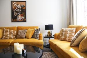 a living room with two yellow couches and a table at The Knaresborough Retreat in Knaresborough