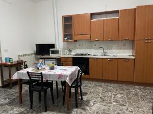 uma cozinha com uma mesa com cadeiras e um fogão em casa monte maggio em Cassino