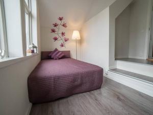 a bedroom with a bed with a purple comforter at Modern apartment 7 min to center in Bergen