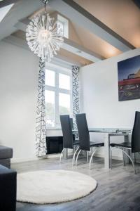 a dining room with a table and chairs and a chandelier at Modern apartment 7 min to center in Bergen