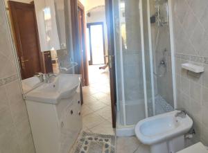 une salle de bain avec douche, lavabo et toilettes dans l'établissement Isola Rossa La Paduledda Appartamento vista mare Il Mirto, à Cascabraga 28 autres photos