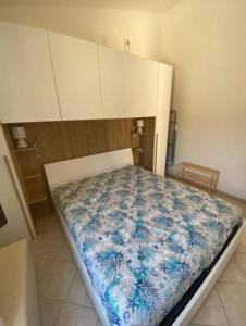 une chambre avec un lit avec une couverture bleue et blanche dans l'établissement Isola Rossa La Paduledda Appartamento vista mare Il Mirto, à Cascabraga