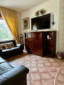 a living room with a couch and a flat screen tv at Villa Porto Selvaggio in Santa Caterina di Nardò