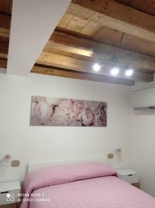 格拉多的住宿－Lucky Home - Juwel im historischen Zentrum，卧室配有粉红色的床和墙上的绘画作品