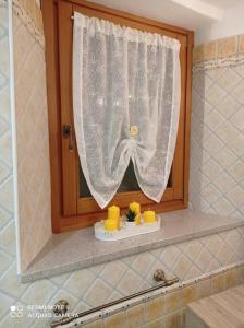 a bathroom with a shower curtain and a window at Lucky Home - Juwel im historischen Zentrum in Grado