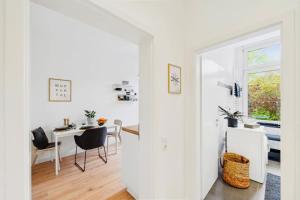 een witte woonkamer met een tafel en stoelen bij Wuppertaler Altbau-Traum Gutenberg in Wuppertal