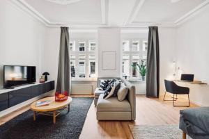 ein Wohnzimmer mit einem Sofa und einem Tisch in der Unterkunft Wuppertaler Altbau-Traum Gutenberg in Wuppertal