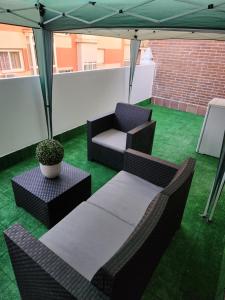 een patio met een bank en stoelen onder een tent bij Hostel Pepe Viajes in Madrid
