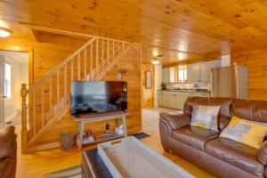 ein Wohnzimmer mit einem Sofa und einem Flachbild-TV in der Unterkunft Family-Friendly Center Ossipee Cabin with Fire Pit! in Center Ossipee