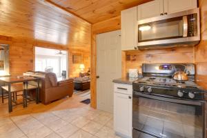 eine Küche und ein Wohnzimmer in einem Blockhaus in der Unterkunft Family-Friendly Center Ossipee Cabin with Fire Pit! in Center Ossipee