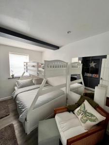 a bedroom with two bunk beds and a couch at Sandy feet retreat in Exmouth +45 photos
