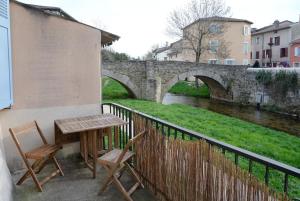 a table and chairs on a balcony next to a bridge at Auberge du Vieux Pont in Brignais