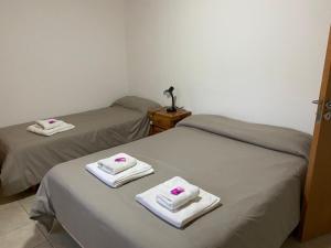 2 camas con toallas en una habitación en Departamentos Lizkar en Esquel