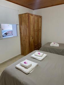 a room with two beds with towels on them at Departamentos Lizkar in Esquel