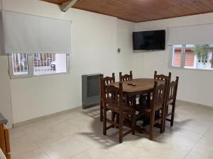 a dining room with a table and chairs and a television at Lizkar Alojamientos in Esquel