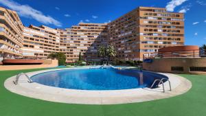 a large swimming pool in front of a large building at Mediterranean apartment Rosas in Roses