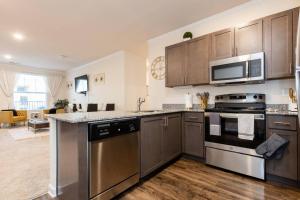 a kitchen with stainless steel appliances and wooden cabinets at Elegant 2BR Suite in Downtown Waxhaw w. Pool 