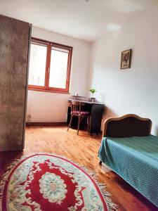 a room with a bed and a table and a rug at Apartman 5ra in Vrnjačka Banja