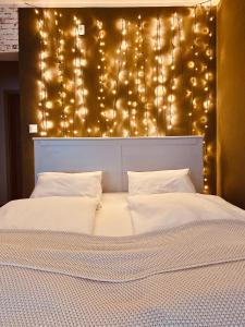 a bedroom with a large bed with lights above it at Bohemian in Šamorín