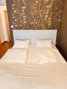 a bed with a headboard with lights on it at Bohemian in Šamorín