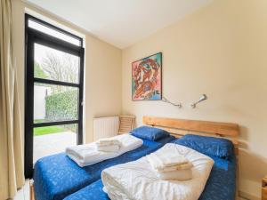 two beds in a room with a window at Apartment, located a stone's throw away from the sea in Cadzand-Bad