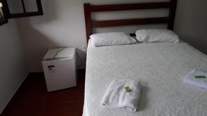 a bedroom with a bed with a towel on it at Pousada São Manoel in Valença