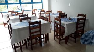 un comedor con mesas blancas y sillas de madera en Pousada São Manoel en Valença