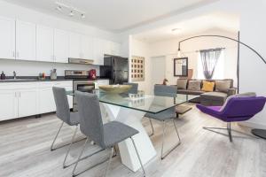 cocina y sala de estar con mesa de cristal y sillas moradas en Home Midtown Miami - Wynwood area with backyard - Art District near to Beach, en Miami