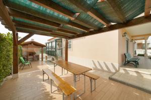 un patio al aire libre con mesa de madera y bancos en Casa do Monte Amarelo, en Fátima
