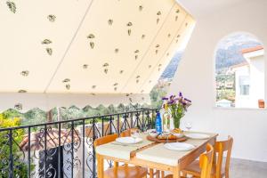 a dining room with a table and chairs on a balcony at New Olivka House in Anavyssos