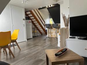 een woonkamer met een flatscreen-tv en een tafel bij Studio Lilouna avec parking privé in Le Tréport