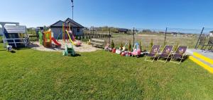 a park with chairs and a playground with a slide at DOMKI U STRAŻAKA GĄSKI -MORZE in Gąski