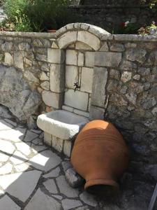 a large pot sitting next to a stone wall at Terra Petra Villa at Psari Trikolonon Gortynia in Psárion