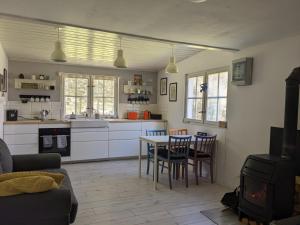 a kitchen and living room with a table and chairs at Szary Domek 