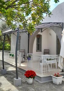 un pergolato bianco con tavolo e sedie di fronte a una casa di Villa Marisole a Torre Canne