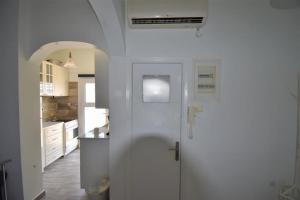 a white kitchen with a door and a sink at Eleni Penthouse Loutraki in Loutraki