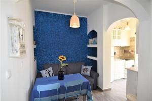 a living room with a couch and a blue wall at Eleni Penthouse Loutraki in Loutraki