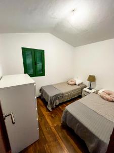 2 camas en una habitación con persianas verdes en CASA DOMINGO 1 en La Santa