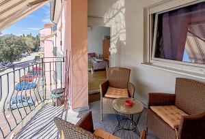 a balcony with chairs and a table and a window at Lungo Mare Apartment with Terrace in Pula