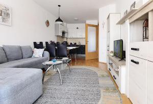 a living room with a couch and a table with a tv at Lungo Mare Apartment with Terrace in Pula +25 photos