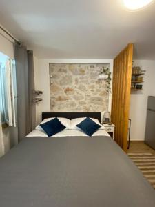 sypialnia z dużym łóżkiem z niebiesko-białymi poduszkami w obiekcie Little Oasis w Szybeniku