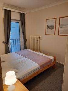 une chambre avec un grand lit avec une fenêtre dans l'établissement Zonnig en gezellig appartement met zijdelings zeezicht en zwembad in Koksijde, à Coxyde 19 autres photos
