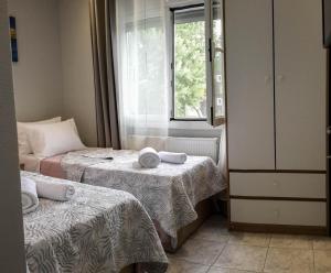 a small room with two beds and a window at Villa Kalliope in Keramoti