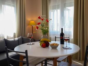 a table with a bowl of fruit and a bottle of wine at Villa Kalliope in Keramoti