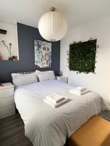 a bedroom with a white bed with two towels on it at Sandy feet retreat in Exmouth