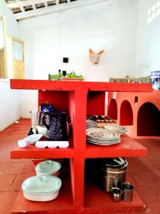 ein rotes Regal mit Tellern und Geschirr darauf in der Unterkunft Casa La Escondida Tlacotalpan in Tlacotalpan