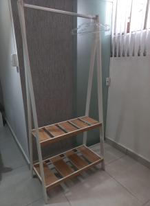 ein Holzregal in einem Raum neben einer Tür in der Unterkunft Suíte confortável em Cabo Frio in Cabo Frio