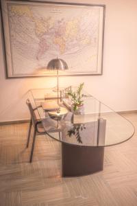 un tavolo in vetro e una sedia in una stanza con una mappa di Il Verdi home a Caserta