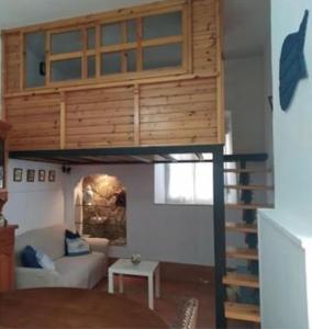 - un lit en mezzanine dans un salon avec un canapé dans l'établissement Bellamar Playa Santa Maria, à Naveces